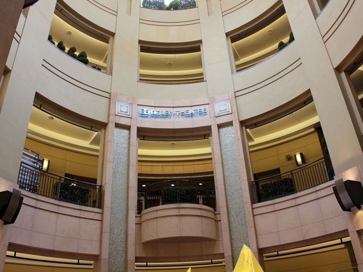 This image shows the interior of a multi-story building with balconies and lighting. A sign with text is displayed on one of the levels.